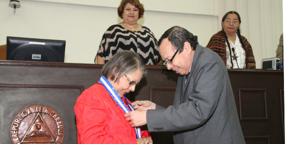 "Presidente AN colocando medalla a Doris Tijerino"